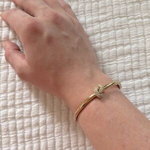 Gold Kate Spade bracelet with rhinestone knot design